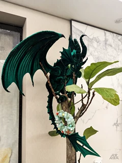 Green and black handmade pipe cleaner dragon displayed with plants, buyer photo